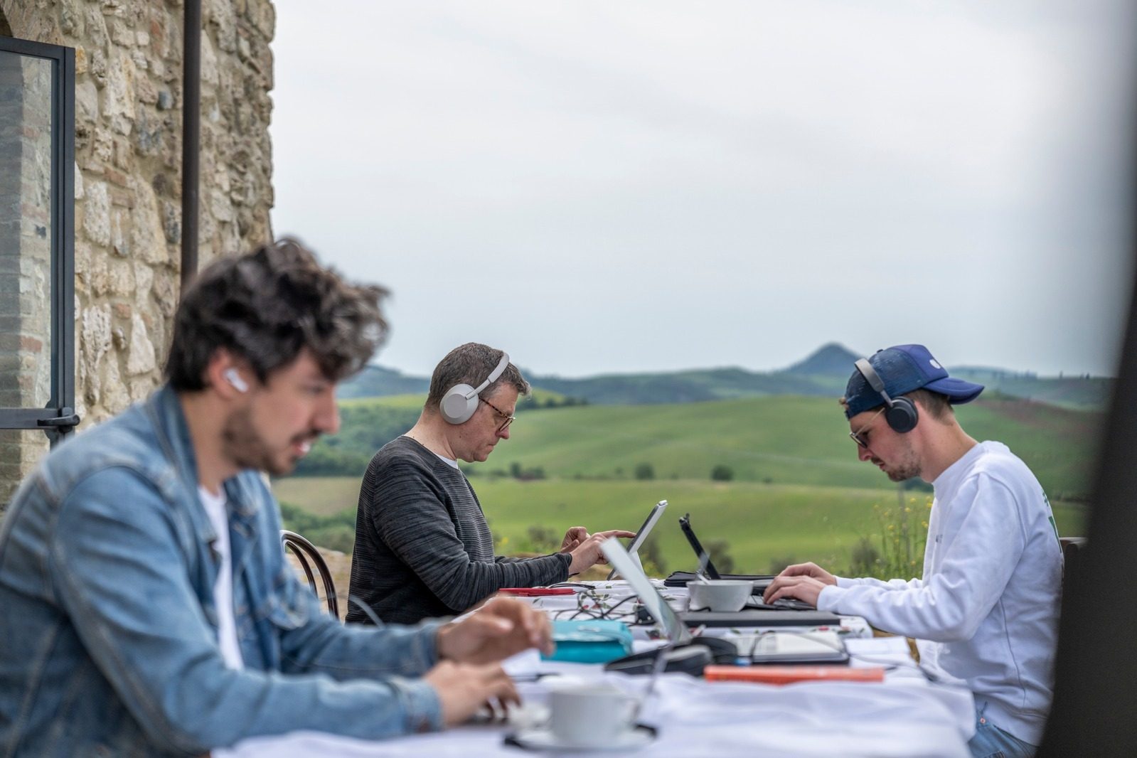 Founders working on laptops with headphones